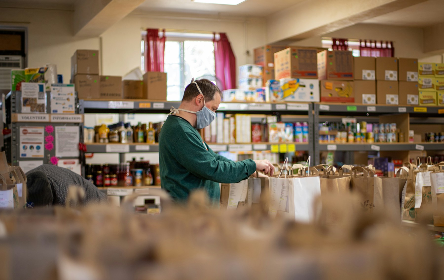 Volunteer preparing bags inside a community pantry