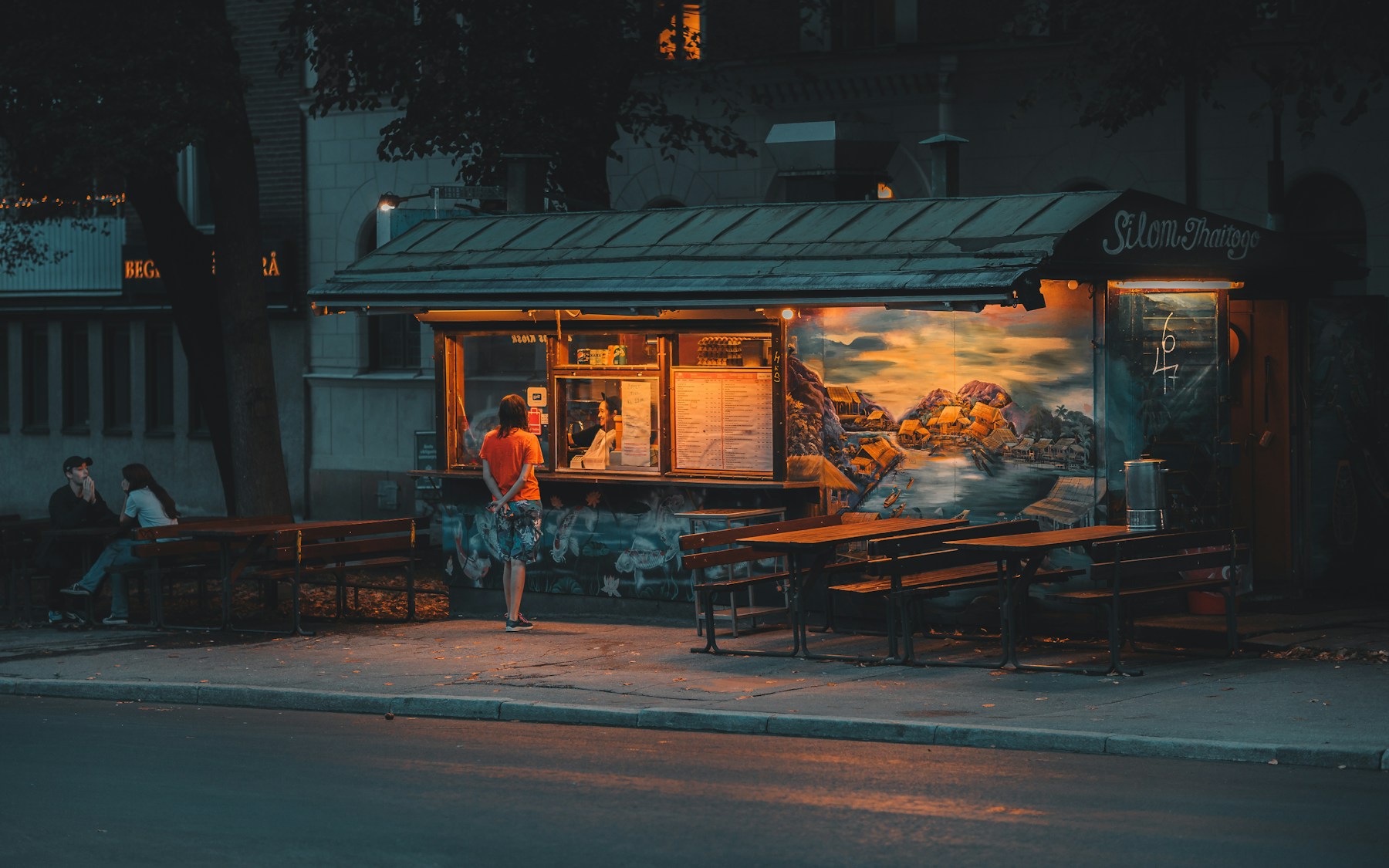 Small glowing food stand at dusk